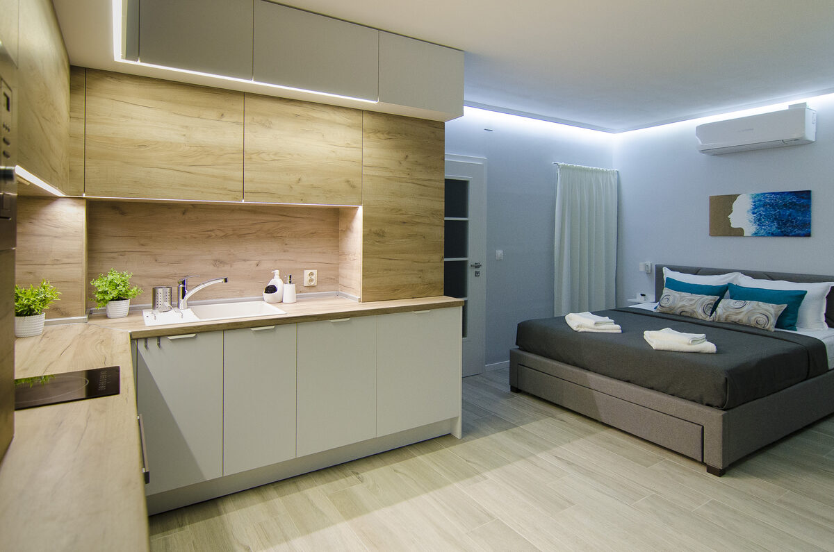 Open-plan studio with modern kitchen, LED lighting, and comfortable queen bed