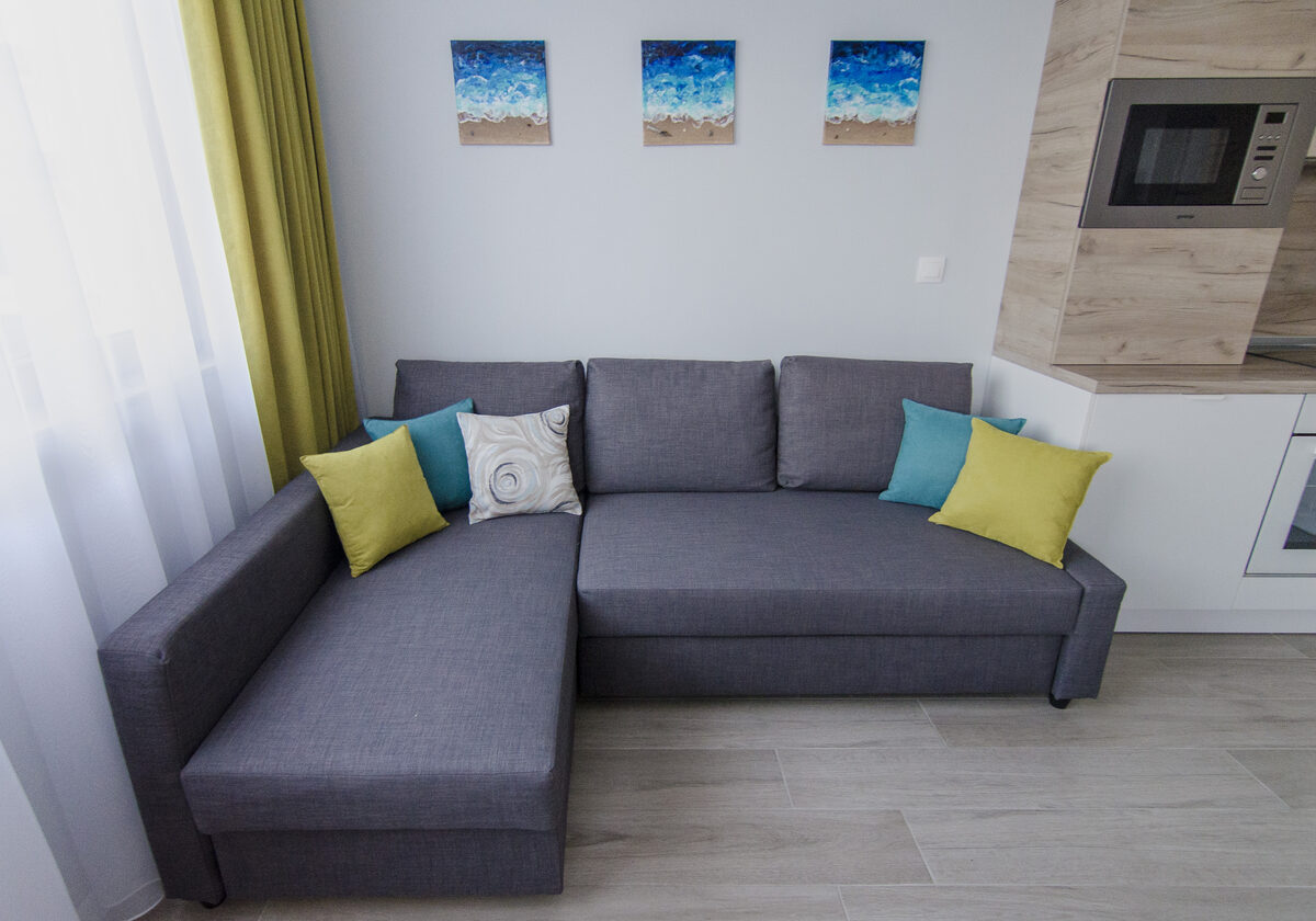 Gray sectional sofa with vibrant teal and lime green accent pillows