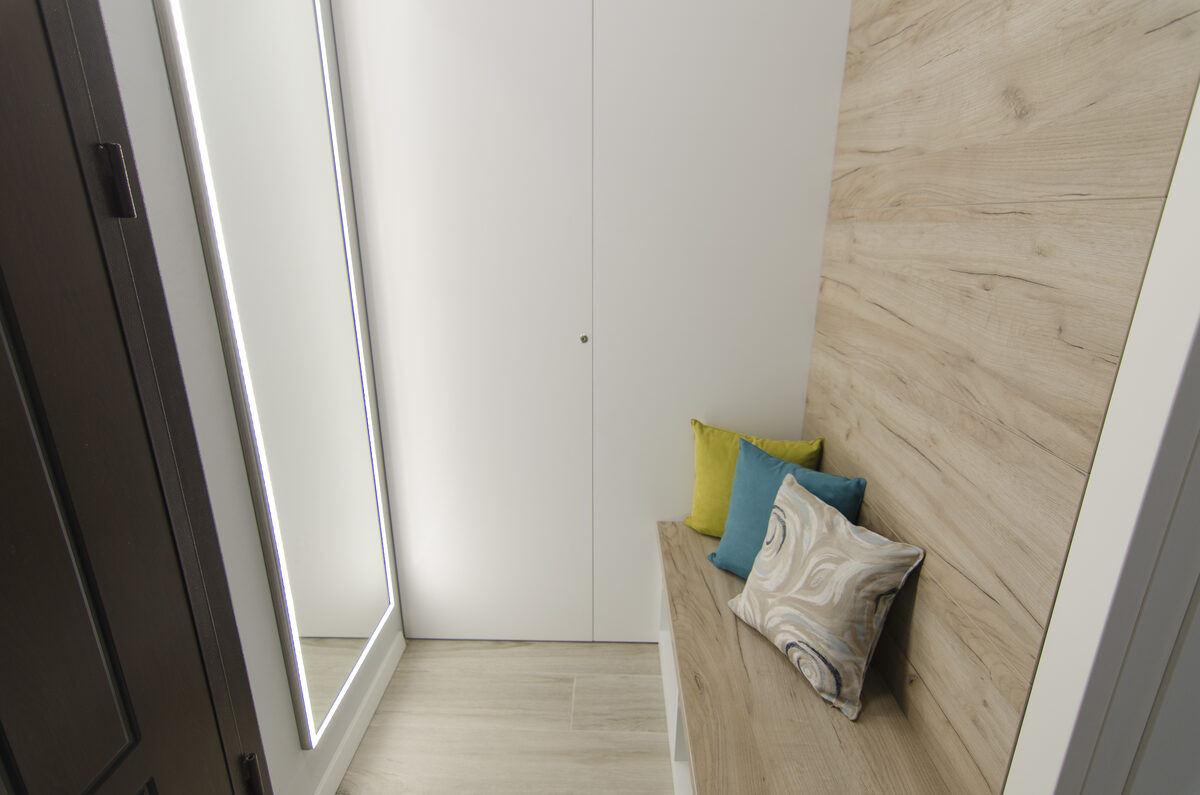 Apartment entrance hallway with built-in storage bench and accent pillows