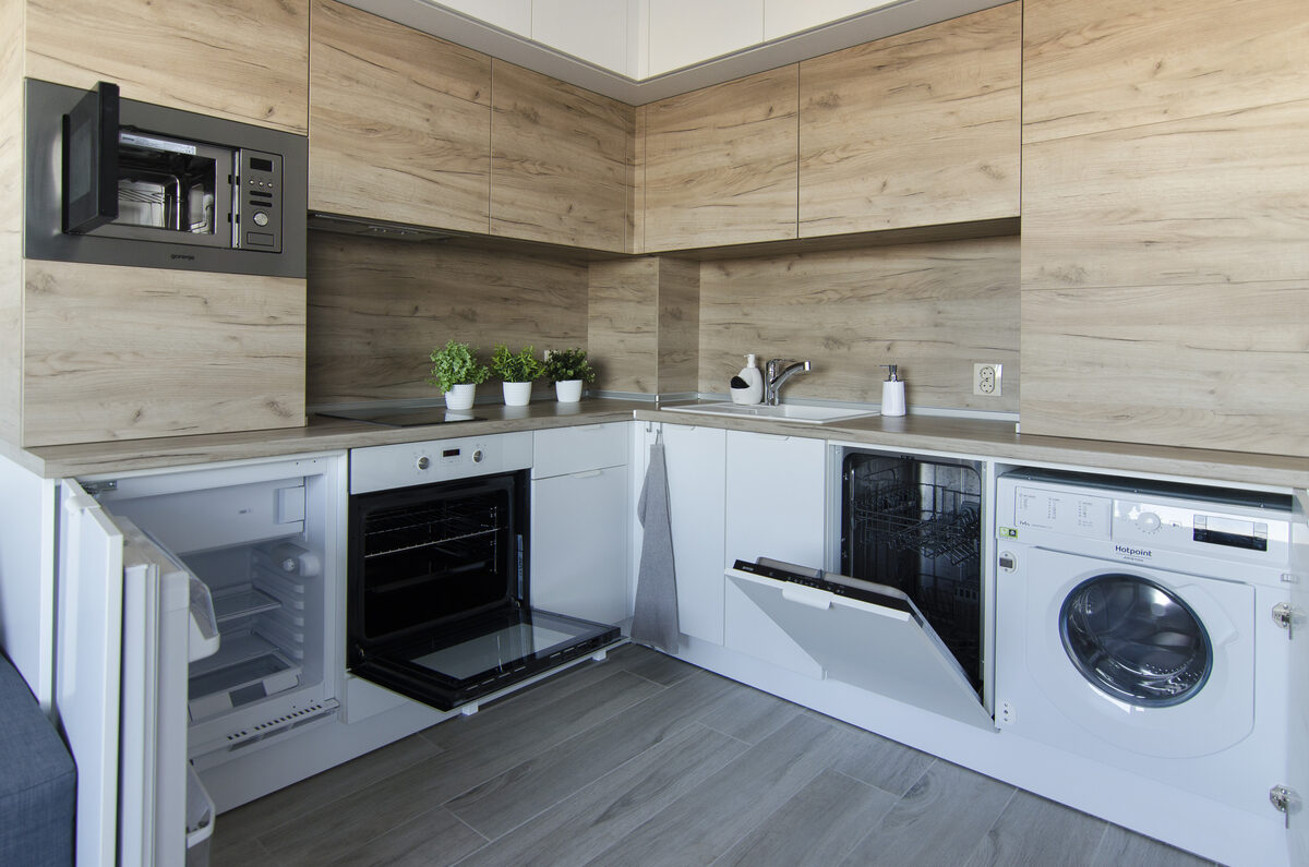 Fully-equipped kitchen showing built-in dishwasher, washing machine, and oven