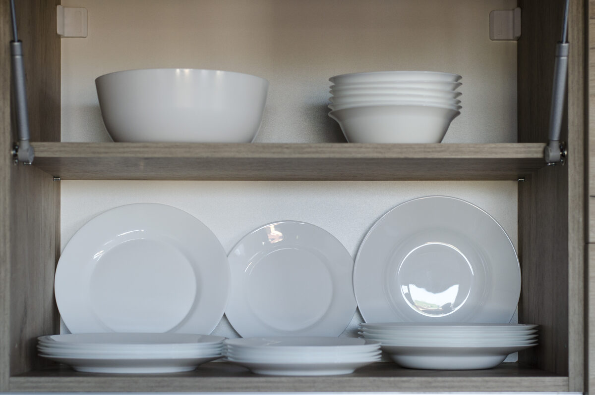 Kitchen cabinet with complete dinnerware set including plates and serving bowls