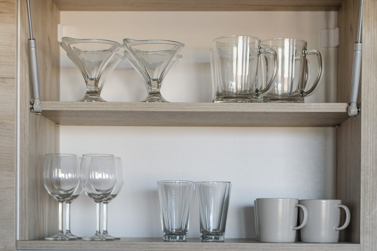 Kitchen cabinet with wine glasses, beer mugs, and complete glassware collection